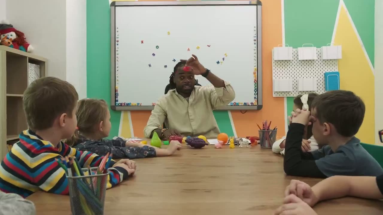 A teacher giving a lesson to children in a classroom